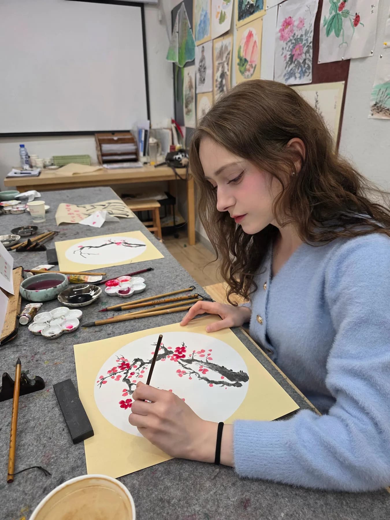 A traveler practicing traditional Chinese brush painting during a hands-on cultural experience