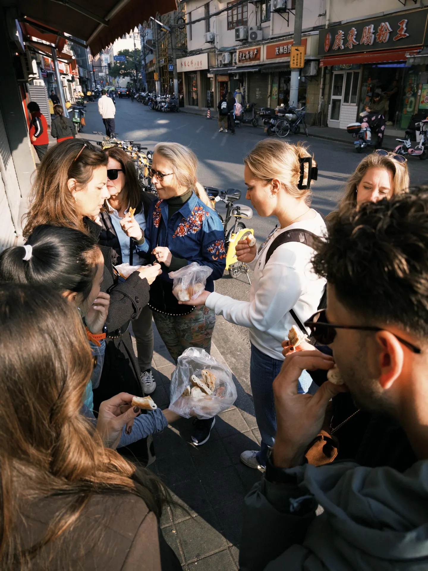 Travelers sharing street food on a Shanghai neighborhood walk