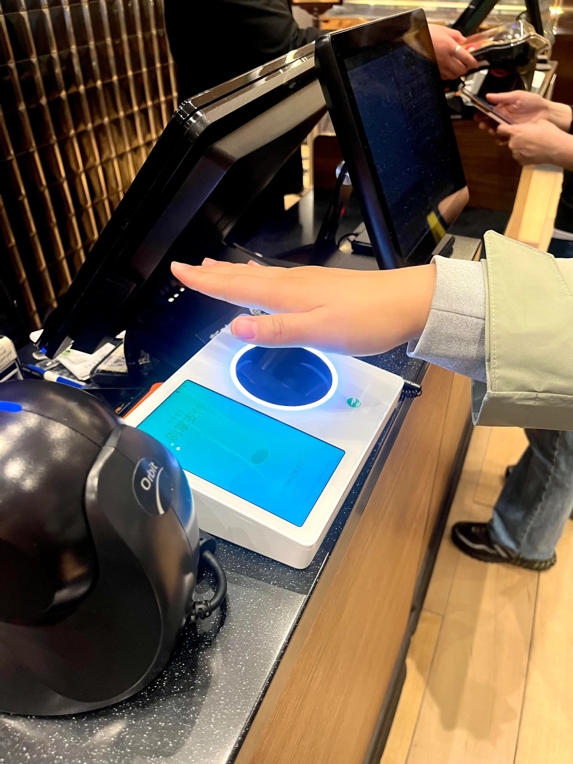 Traveler completing a mobile payment at a counter in China
