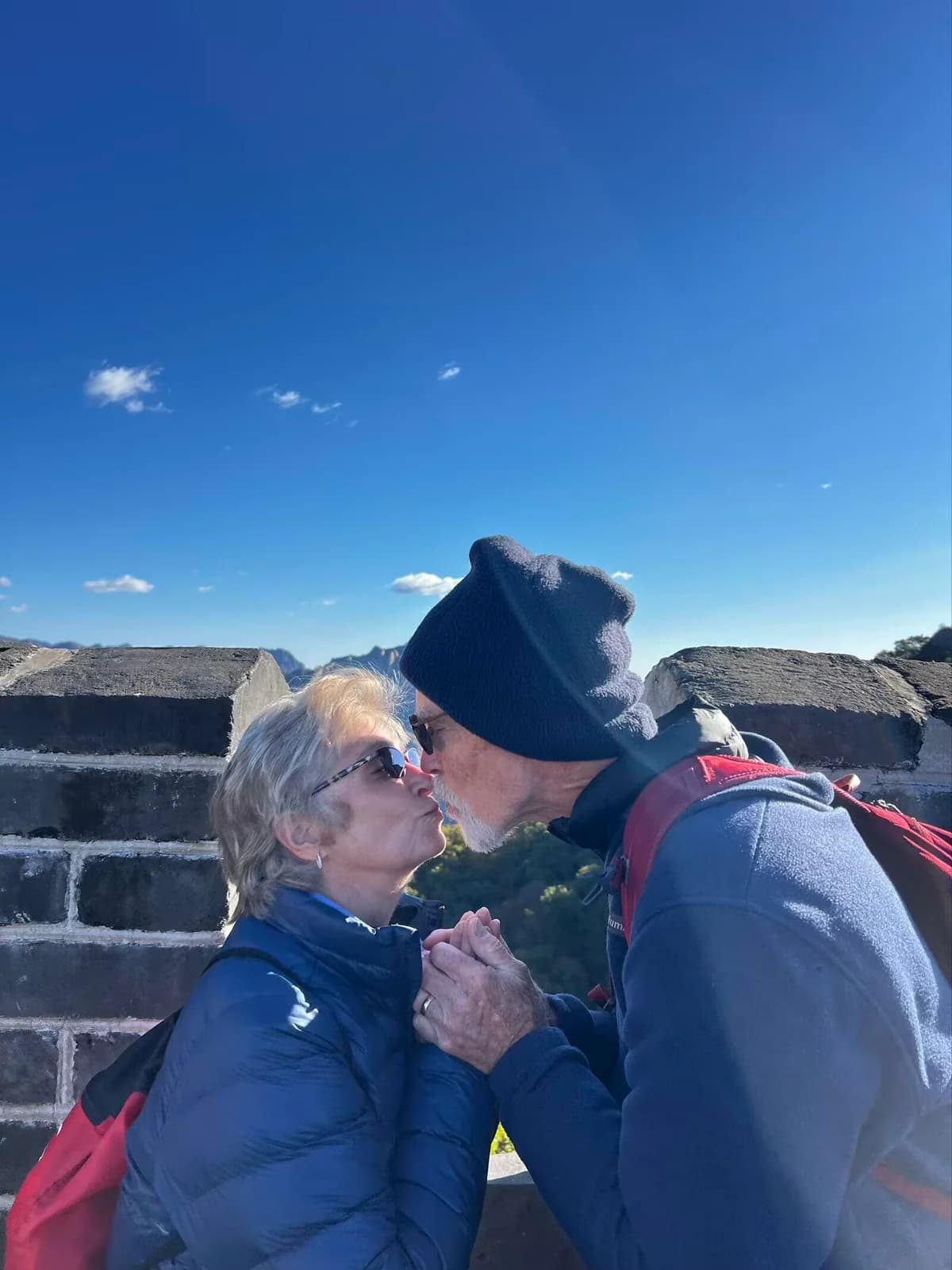 Older couple sharing a kiss on the Great Wall at Mutianyu near Beijing