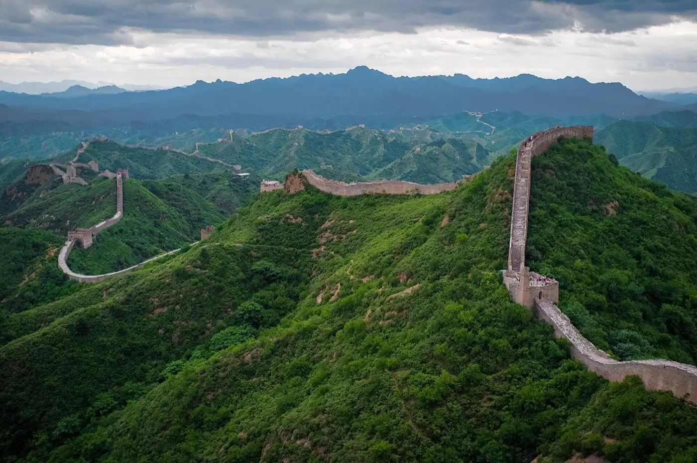Great Wall of China crossing green mountains in clear light
