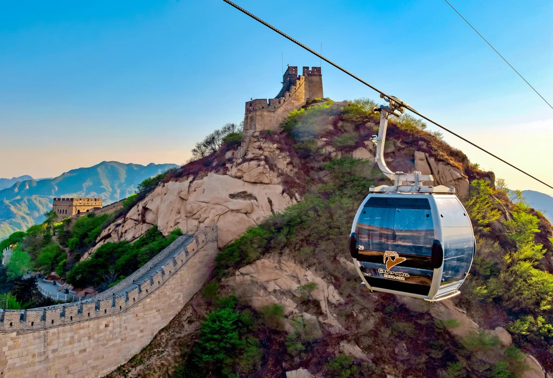 Cable car beside Great Wall ramparts crossing a mountain ridge
