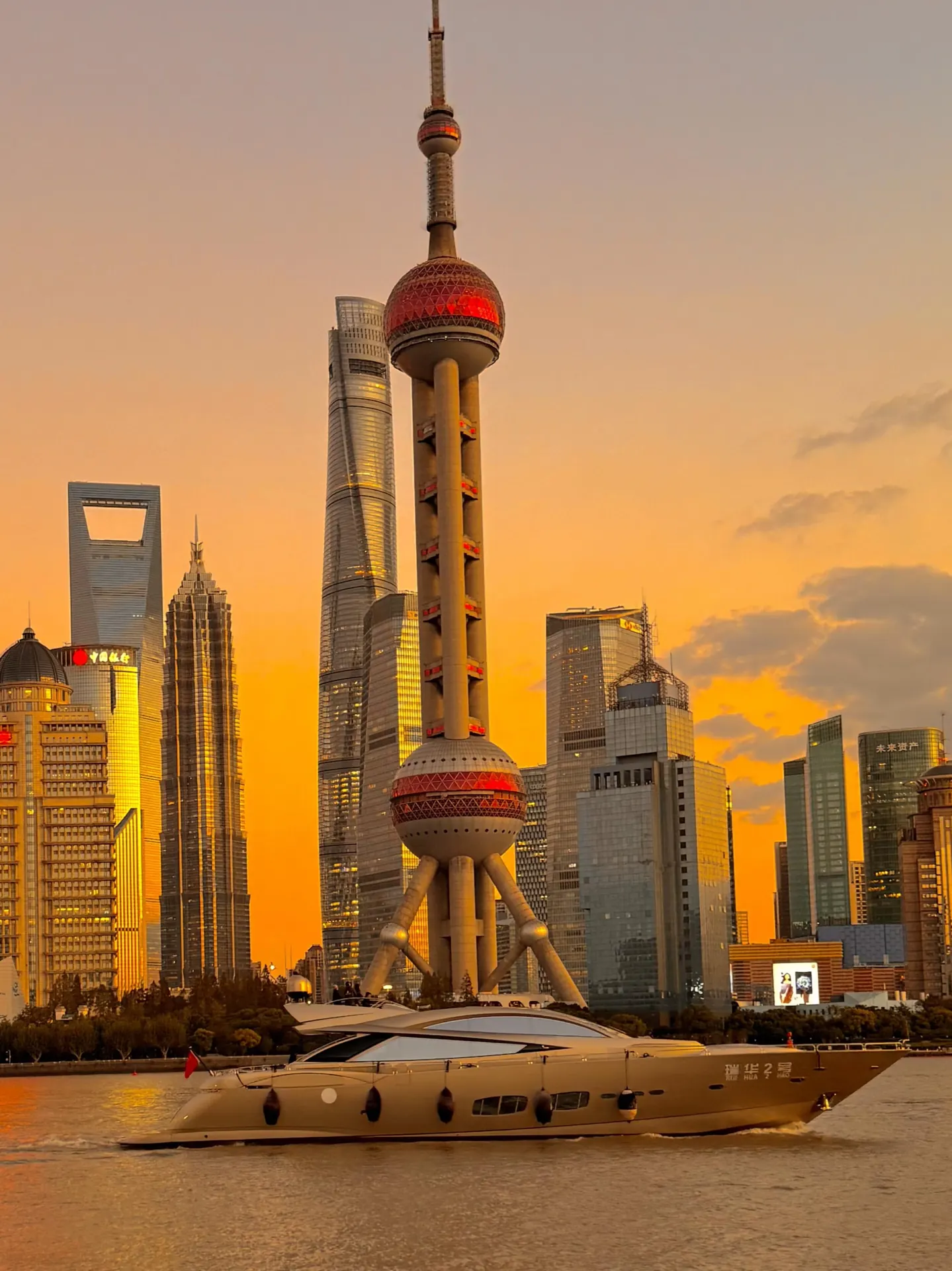 Shanghai Pudong skyline and a boat on the Huangpu River at sunset