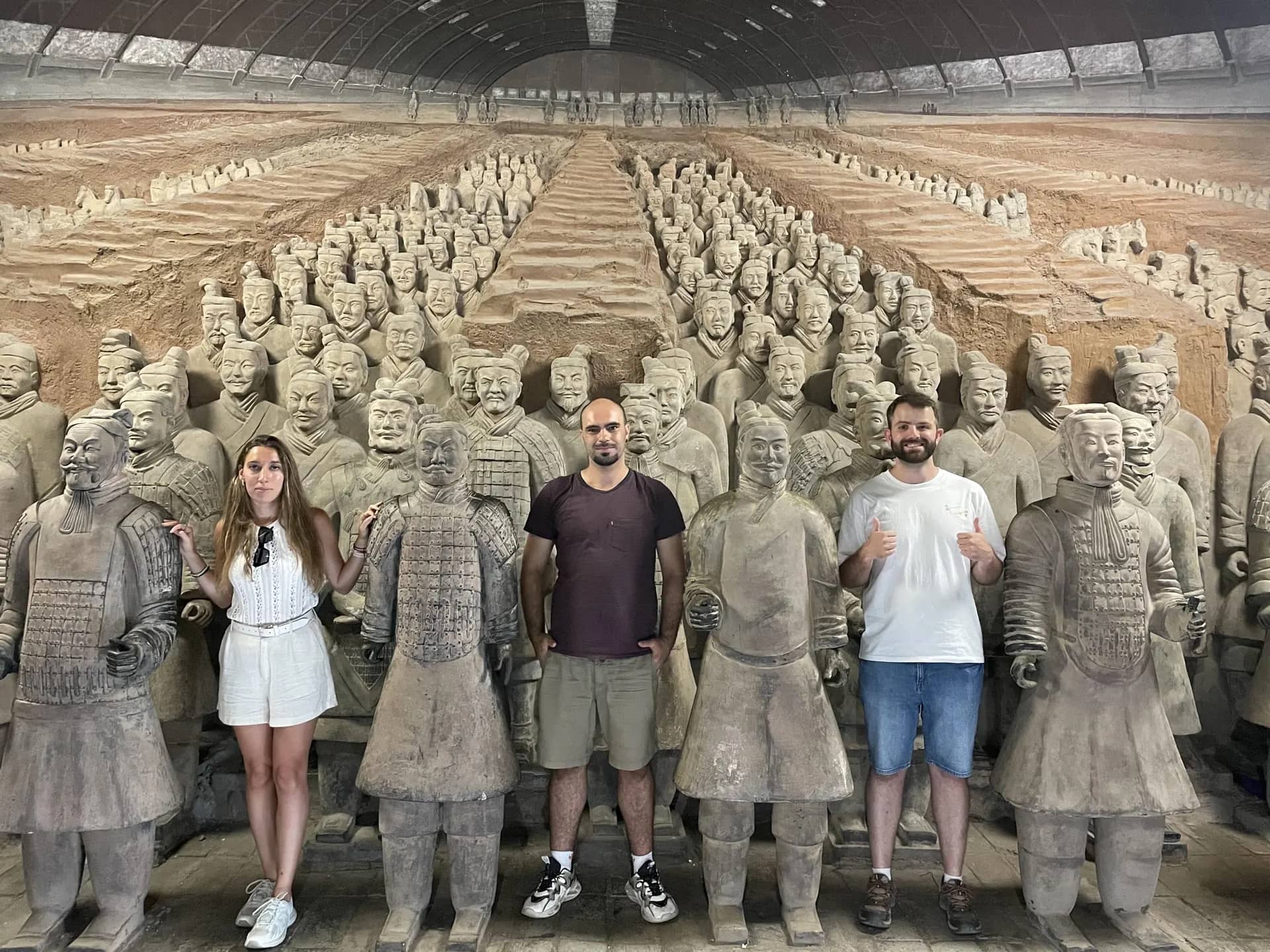 Travelers posing beside Terracotta Army figures in Xi'an
